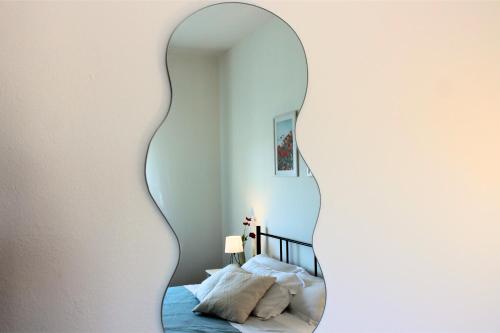 a mirror on a wall next to a bed at Dimidium Apartment in Guspini