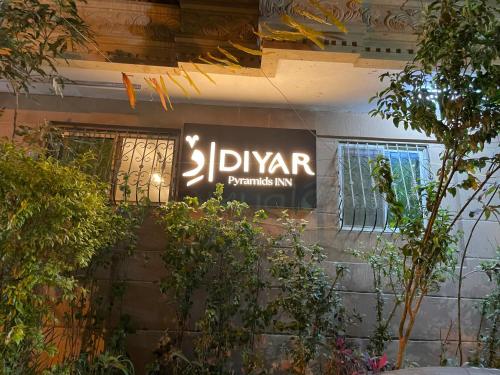 a sign on the side of a building with plants at Diyar Pyramids Inn in Cairo