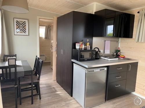 eine kleine Küche mit einem Tisch und einer Mikrowelle in der Unterkunft Hestheimar in Hella