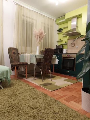 uma sala de jantar com mesa e cadeiras e uma cozinha em Stancicmilena em Pozarevac