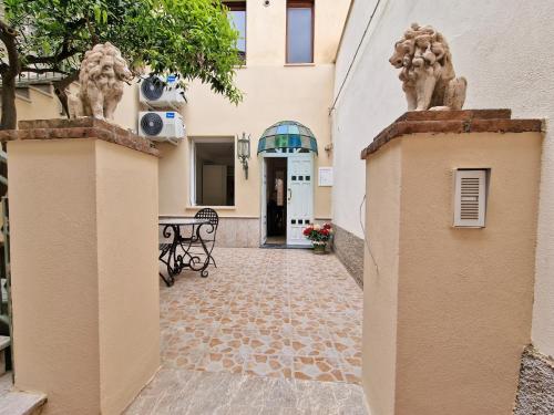 - l'entrée d'un bâtiment avec une cour dotée d'une table dans l'établissement LA BARONESSA CHARMING HOUSE with parking, à Taormine
