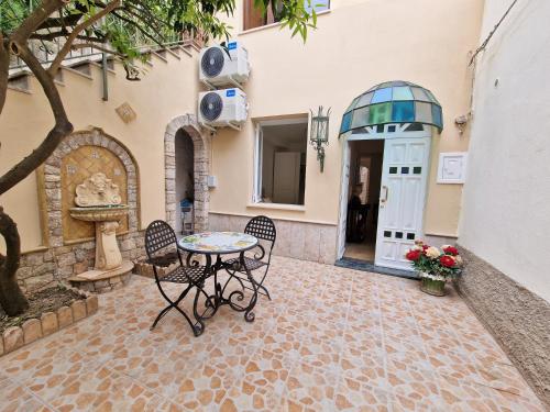 une terrasse avec une table et des chaises devant un bâtiment dans l'établissement LA BARONESSA CHARMING HOUSE with parking, à Taormine