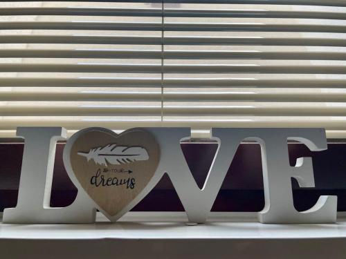 a sign with a heart next to a window at Olea Mar apartma in Pobegi