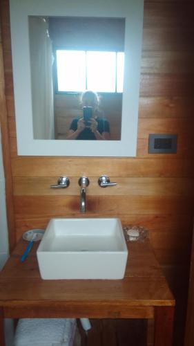 a person taking a picture of a sink in a bathroom at La casita del bosque in Punta Indio