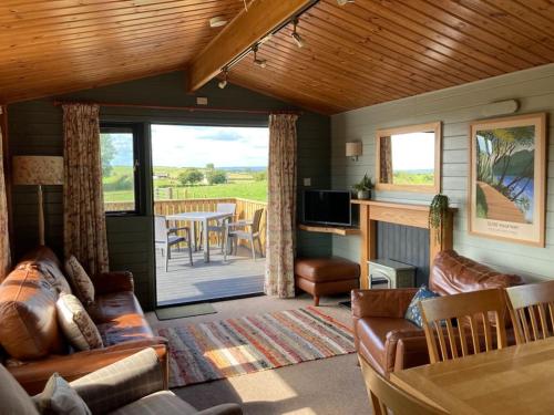 Carluke的住宿－The Lodge at Blackhill Farm，带沙发的客厅和用餐室