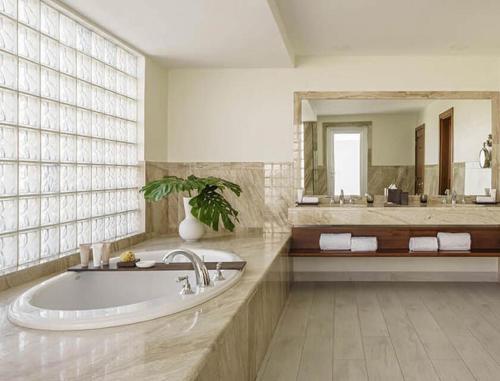 a bathroom with a tub and a large mirror at Aurora Anguilla Resort & Golf Club in Rendezvous Beach