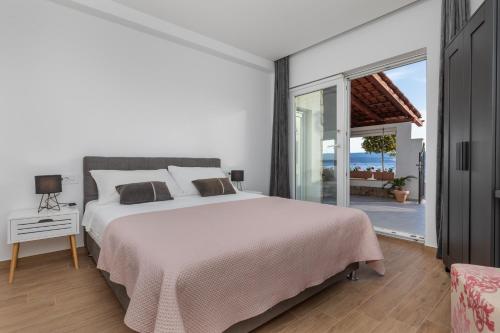 een slaapkamer met een groot bed en een groot raam bij Beach house Medići in Mimice