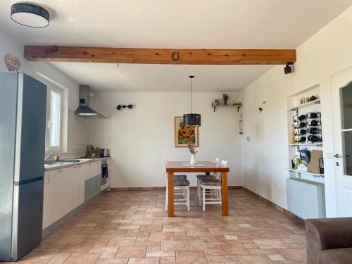 uma cozinha com uma mesa de madeira e uma cozinha com um frigorífico em Olea Mar apartma em Pobegi