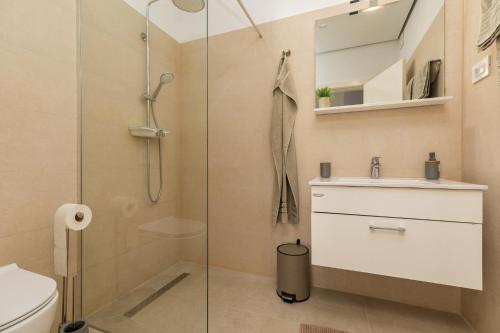 een badkamer met een douche, een wastafel en een toilet bij Beach house Medići in Mimice