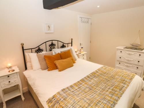 Un dormitorio con una gran cama blanca con almohadas naranjas. en Lyme Views, en Lyme Regis
