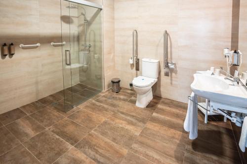 a bathroom with a toilet and a sink and a shower at Hotel Puente de Alconétar in Garrovillas