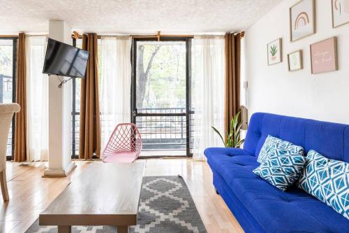 a living room with a blue couch and a tv at Park Narvarte in Mexico City