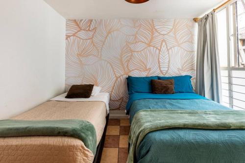 a bedroom with two beds and a wall at Park Narvarte in Mexico City