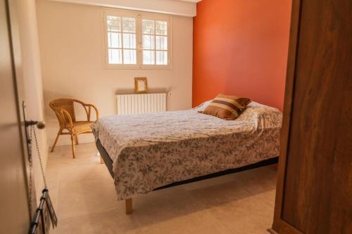 a bedroom with a bed and a window and a chair at Appartement dans maison de campagne lumineuse in Orange