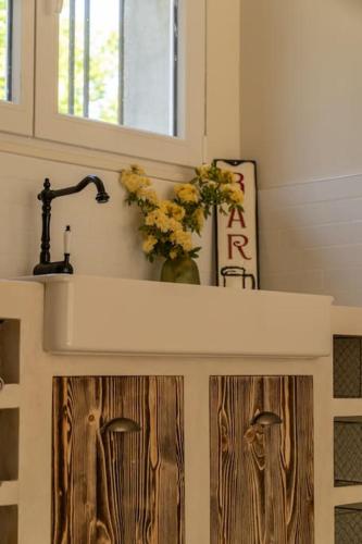 a kitchen counter with a sink and flowers on top at Appartement dans maison de campagne lumineuse in Orange