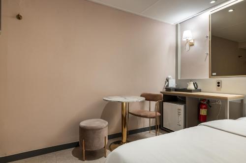 une chambre d'hôtel avec un lit, une table et un comptoir dans l'établissement Greaten Hotel, à Séoul