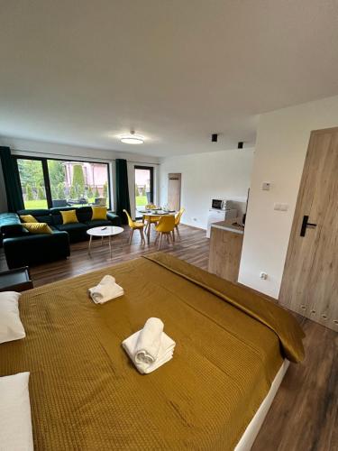um quarto com uma cama com duas toalhas brancas em Domki i Apartamenty Wypoczynkowe Lidzbark em Lidzbark