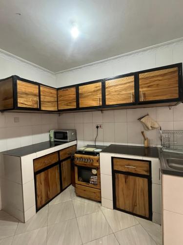 cocina con armarios de madera y fogones en Bomani House en Arusha