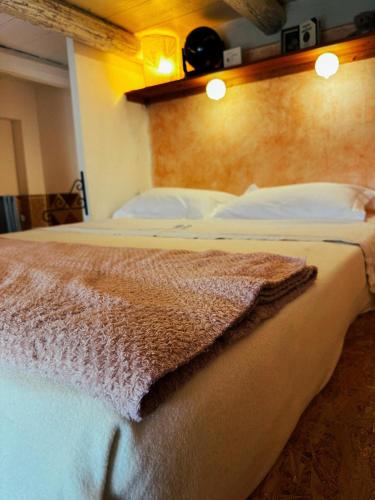 une chambre avec un lit avec une couverture dessus dans l'établissement Casaluna, chambre climatisée dans maison de village, à Sotta