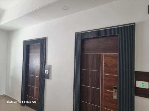 una puerta de madera en una habitación con espejo en MSPride en Tirupati