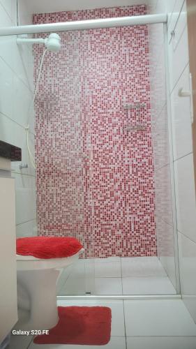 a bathroom with a shower with a toilet and a red rug at DUNAS RESIDENCE CASA 02 in Santo Amaro