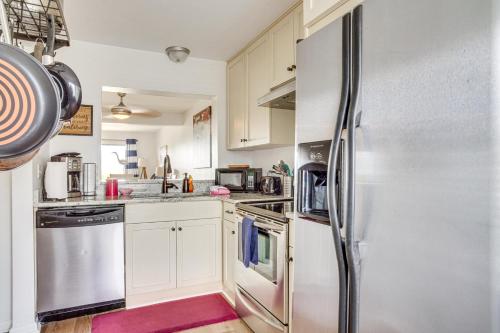 a kitchen with white cabinets and a stainless steel refrigerator at Harbor Island Condo with Pool Access Walk to Beach! in Oceanmarsh Subdivision