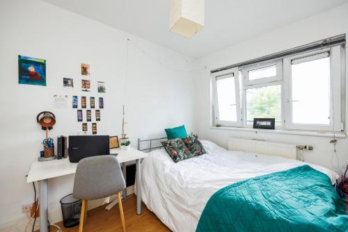 a bedroom with a bed and a desk with a computer at Trendy four bed flat in islington in London