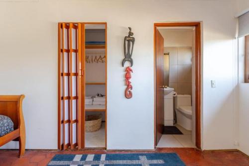 ein Bad mit einer Tür, die sich zu einem Bad mit einem WC öffnet in der Unterkunft Del Alto Reñaca in Viña del Mar