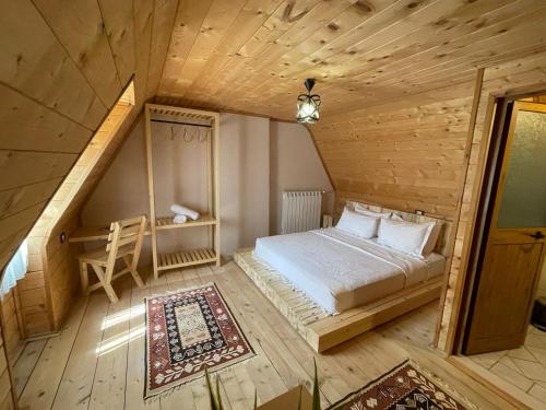 1 dormitorio con 1 cama en una habitación de madera en Guesthouse "Gjin Thana", en Theth