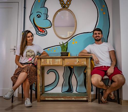 a man and woman sitting at a table with a baby on it at Araucária Hostel in São Bento do Sul