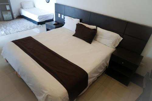 a bedroom with a large bed with a black headboard at Serenity Suites Casa Boutique in Bucaramanga