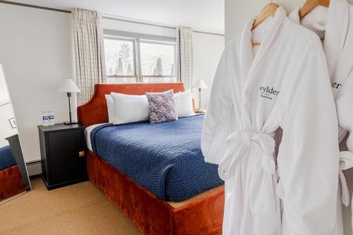 een slaapkamer met een bed en een badjas op een rek bij The Farmhouse at Wylder Windham in Windham
