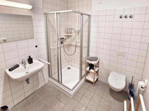 a bathroom with a shower and a sink and a toilet at WO Apartments am Klinikum Wolfsburg in Wolfsburg