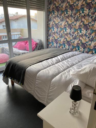 Schlafzimmer mit einem Bett mit einem Tisch und einem Fenster in der Unterkunft Proche centre T2 avec Terrasse in Biarritz