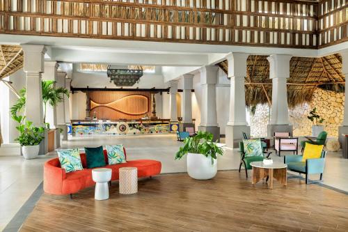 a lobby with a red couch and colorful chairs at Sunscape Dominicus La Romana - All Inclusive in La Romana