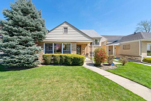 a house with a grass yard and a tree at Urban Oasis - Kid Friendly - Quiet Street in Skokie