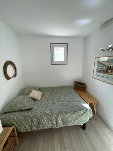 une petite chambre avec un lit et une table dans l'établissement Appartement T2 proche mer, à La Pironnière