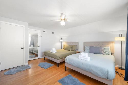 a white bedroom with a bed and a couch at Urban Oasis - Chic Design - Game room/Movie room in Skokie