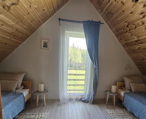 a bedroom with two beds and a window at SierPlejs Hill - domki przy szlaku w Górach Sowich in Sierpnica