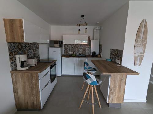 une cuisine avec des armoires blanches et un comptoir dans l'établissement Bonamour Calluna, à Capbreton