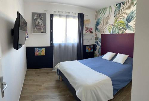 Schlafzimmer mit einem blauen und weißen Bett und einem Fenster in der Unterkunft Magnifique villa avec piscine à 20 min de hossegor in Saint-Geours-de-Maremne