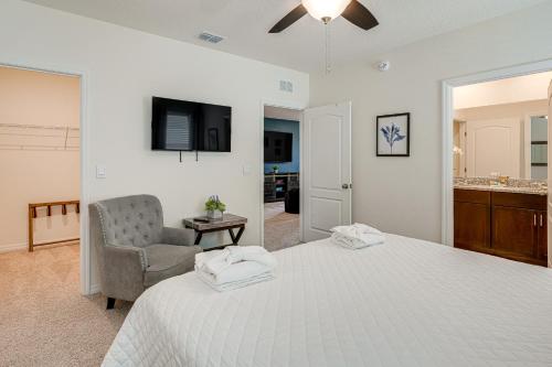 a bedroom with a bed and a chair and a television at Disney Area Vacation Rental with Game Room and Pool! in Davenport