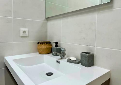 une salle de bain avec un lavabo blanc et un miroir dans l'établissement Moderne entre lac et océan, à Biscarrosse