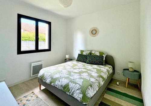 une chambre avec un lit et une fenêtre dans l'établissement Moderne entre lac et océan, à Biscarrosse