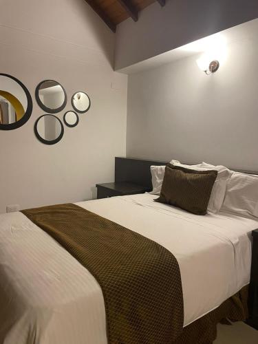 a bedroom with a large white bed and a mirror at Serenity Suites Casa Boutique in Bucaramanga