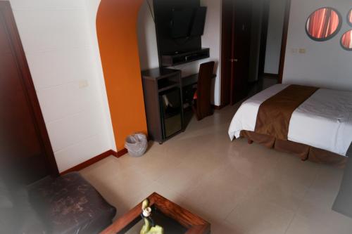 a hotel room with a bed and a tv at Serenity Suites Casa Boutique in Bucaramanga