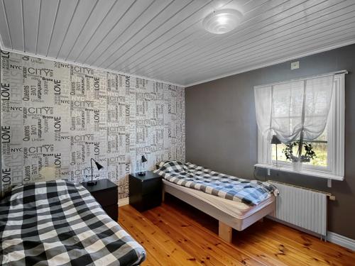 a room with two beds and a window in it at Spacious Cabin for Work Crews, 10 Beds! in Ingelstad
