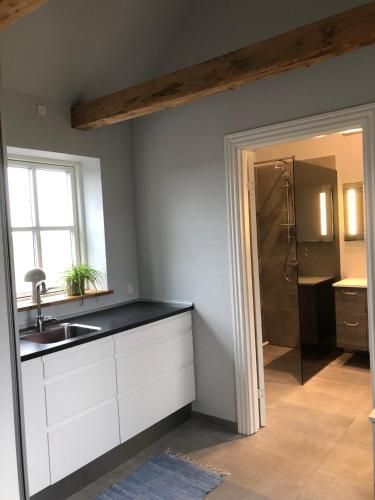 a kitchen with a sink and a refrigerator and a window at Hyggeligt hus på landet mellem Billund og Vejle in Bredsten