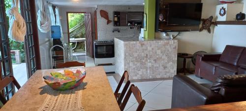 a kitchen and dining room with a table with a bowl on it at Casa Martureza in Angra dos Reis