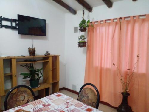 a dining room with a table and a television at La Soñada in Malargüe